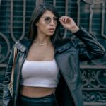 Stylish woman in leather jacket and glasses posing in Mexico City.